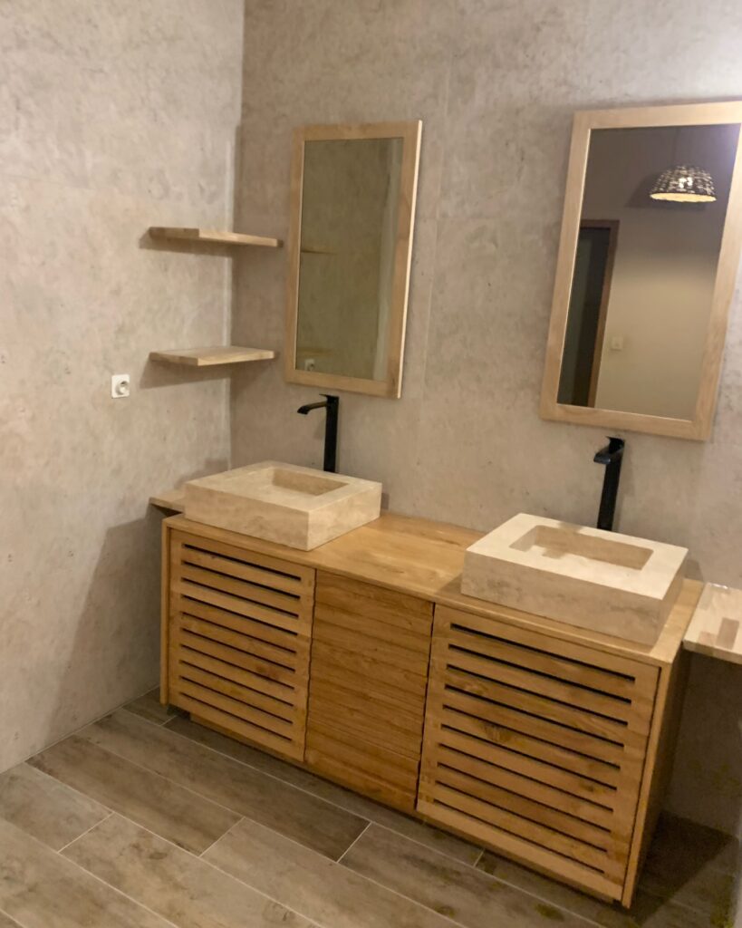 Salle Bain Bois Naturel et Vasques Pierre Modernes Salle de bain moderne avec meuble vasque double en bois clair, deux vasques en pierre naturelle et robinetterie noire, murs beiges.