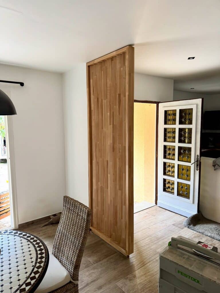 Cloison en bois massif : séparation de pièce design Cloison de séparation en bois clair massif installée dans un salon moderne avec mobilier naturel.